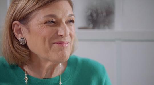 Close up of Debbie, speaking to camera, inside her house.